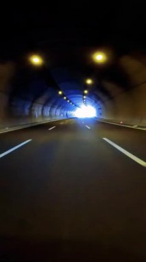 Otoyoldaki tünelden çıkarken, araba perspektifi sonunda ışığı gösteriyor. Otoyol tünel deneyimi, araba görüntüsü ışığa çıkıyor. Otoyol tünelinde araba yolculuğu, karanlıktan aydınlığa geçiş..