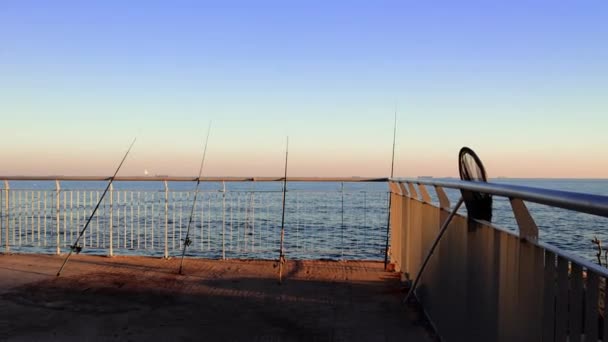 Рыболовные Удочки Выстроились Набережной Фоне Заката Моря Любители Рыбалки Вечерняя — стоковое видео