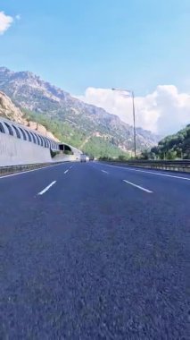Asfalt yolda dağ yolculuğu, arabalar manzaralı. Karayolu asfaltı dağlardan geçiyor, birinci şahıs sürüş. Araba asfalt dağ yolunda ilerliyor. Manzaralı. Yüksek kaliteli görüntüler