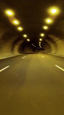 Araba tünele giriyor, otoyol karanlığa gömüldü. Arabadan tünel yaklaşımı, otoyol perspektifi. Tünele otoban yolculuğu, arabalardan görüldü..