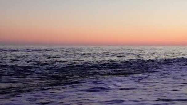 波の後の波は日没時に砂浜に転がります それぞれの波は 穏やかなビーチ夜の本質を捉えています ビーチを包むリズミカルな波のサンセットシーン 高品質の4K映像 — ストック動画