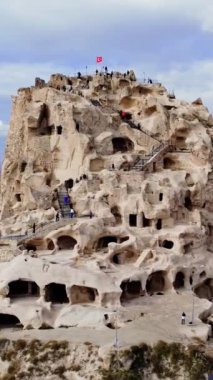 Drone görüntüsü, Kapadokya 'daki Uchisar Kalesi' nin seyahat cazibesini yakalıyor. Uchisar, bir seyahat mücevheri, Cappadocias manzarasında göze çarpıyor. Seyahat meraklıları için ideal, Uchisar Kapadoksias güzelliğinin somut örneği.