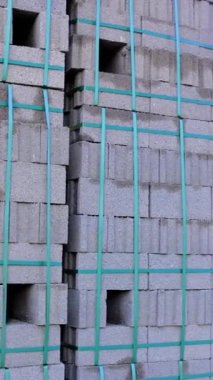 Bloklar inşaat malzemesi olarak kullanılıyor. Blok şeklinde yapı malzemesi, paletlenmiş. Blok yapı malzemesine sahip inşaat alanı, tamamlanmamış yapı arkaplanı.