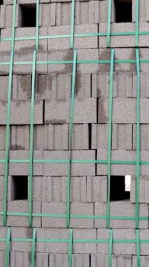 İnşaat alanındaki paletlerin tuğlaları. Palet tuğla istiflemiş, inşaat alanı geçmişi var. Paletlerde tuğlalar, tamamlanmamış bina zeminleri olan bir site. Yüksek kalite 4k görüntü