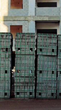 Paletlerin üzerinde sünger taşları olan inşaat alanı inşaat çalışmalarını gösteriyor. Yapı malzemelerinin oluşturulduğu çok sayıda blok, ön plandaki tamamlanmamış yapı önplanlarını engelliyor