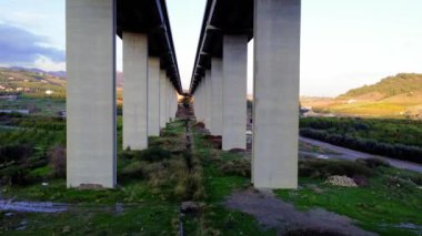 İnsansız hava aracı bir dağ viyaoluğunun beton destekleri arasında yol alıyor. Hava perspektifinden görülen viyadük yapısı. İnsansız hava aracı manevra yaparken viyadüklerin karmaşık dizaynını keşfedin..