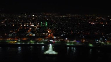 Mersin 'in panoramik drone görüntüsü, geceleri aydınlatılmış şehir manzarası. Hava görüntüleri aydınlatılmış şehir manzarasını çeker, Mersin 'in gece güzelliğini gözler önüne serer. Mersin 'de bir gece, aydınlatılmış şehir manzarasının insansız hava aracı videosu.