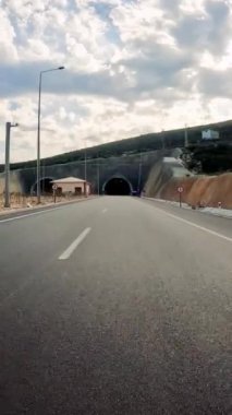 Araba otobanda tünele giriyor, karanlığın yutma yolunu gösteriyor. Araç görüntüsü, tünel girişi ve otoban yolculuğu araçların perspektifi, aydınlatma aracı, tünel deneyimi. 