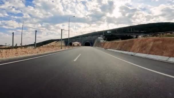 車は高速道路のトンネルに入り 暗闇が循環する道を示しています 車両の視点からトンネルへの車 トンネル入り口 ハイウェイの旅 車のハイライト トンネル体験を捉える — ストック動画