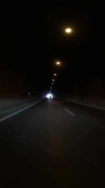 Araba aydınlık tünelden çıkıyor. Aydınlatılmış tünelden, aydınlatma yolculuğundan video görüntüleri yakalıyor. Aydınlatılmış tünel çıkışına odaklan, içerideki karanlıkla zıtlığı göster. Yüksek kalite 4k görüntü