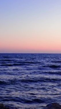 Gün batımında deniz yüzeyinden izlemek, sakin dalgaları yakalamak, sakin atmosferde gün batımını izlemek. Dalga, güneş ufkun altına batarken görülebilen gün batımı huzurlu bir dalga sunuyor, günbatımı sahnesi. Yüksek kalite 4k görüntü