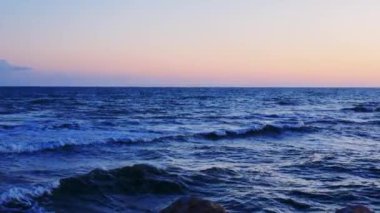 Gökyüzü, deniz manzarası, deniz seviyesinde gün batımı, bu görüntülerde gökyüzü, deniz manzarası, sakin sularla gün batımı, aydınlık gökyüzü, deniz manzarası, canlı bir şekilde gün batımı görülüyor. Yüksek kalite 4k görüntü