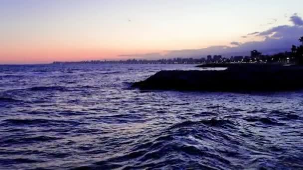 夕暮れの海からの映像 ロマンチックな空 日没を強調する ビデオは ロマンチックな 日没の下の波を特徴としています 太陽の日差しとして終わり ロマンチックで空 日没を示します 高品質の4K映像 — ストック動画