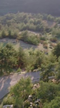 Drone dağ yolunu yakalar, ormandan geçer, dönüşleri renklendirir. Dağ yolunu göstermek için ideal, doğayı döndürmek için. Dağ yolu videoları ve maceralar için mükemmel.. 