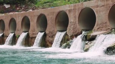 Barajın üzerindeki köprü, şelale huzur verici bir manzara yaratır. Barajı keşfedin, yemyeşil bir şelalenin ortasındaki şelaleyi. Görüntü barajın özünü, şelalenin doğal ortamını yakalar. Yüksek kalite 4k görüntü