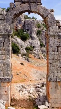 Türkiye 'nin Olba harabelerinin hava görüntülerinde antik şehir kapısı sergileniyor. İnsansız hava aracı, harabeler arasında geçitlerin yapısını, tarihi geçidi araştırıyor. Mimari kalıntıları, manzaradaki geçidi görüntüle. 