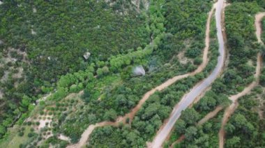 İnsansız hava aracı yeşil kanyondaki dağ, köy yolunu yakalıyor. Dağların panoramik görüntüleri, yemyeşil arazide kıvrılan köy yolları. Manzaralı insansız hava aracı videosuyla dağları, kır yollarını keşfedin.