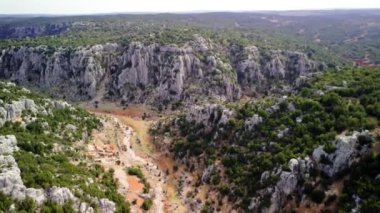 İnsansız hava aracı kanyon, dağ üzerinde uçuyor, panoramik manzara gösteriyor. Video kanyonu, dağ derinliğini ve çevresindeki araziyi yakalar. Kanyonun hava görüntüleri, doğal ortamdaki dağ. Yüksek kalite 4k görüntü