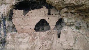 Kilise harabelerinin insansız hava aracı görüntüsü, 7. yüzyılda bir yamaçta inşa edilmiş antik Hristiyan rock kilisesi kalıntıları. Doğu Roma Kilisesi vadiye tepeden bakan bir harabe. Hava arkeolojisi tarihi kilise kalıntılarını yakalıyor.