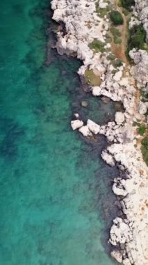 Hava aracı Türkiye 'nin Mersin kentindeki kıyı şeridini ele geçirdi. Görüntüler kayalık deniz kıyısı ve turkuaz kıyı şeridini vurguluyor. Sakin turkuazları keşfedin, sakin mavi sularla kıyı şeridini. 