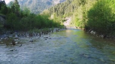 İnsansız hava aracı kayalık arazide temiz su akışını gösteren bir dağ nehri yakalıyor. Dağ nehrinin alçak hava manzarası tenha doğal güzellikleri ortaya çıkarıyor. Dağ nehri görüntüleri doğal manzaralar için idealdir. 