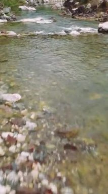 İnsansız hava aracı hızla akan dağ bölgesindeki dereyi yakalıyor. Kayalık deredeki temiz suyun havadan görüntüsü. Dağ deresi görüntüleriyle doğal güzellikleri keşfedin. Yüksek kalite 4k görüntü