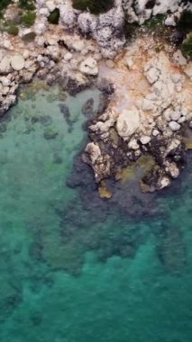 Hava aracı Türkiye 'nin Mersin kentindeki kıyı şeridini ele geçirdi. Görüntüler kayalık deniz kıyısı ve turkuaz kıyı şeridini vurguluyor. Sakin turkuazları keşfedin, sakin mavi sularla kıyı şeridini. 