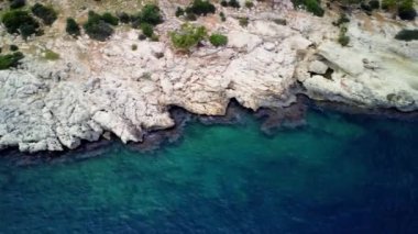 Uçurumun hava aracı görüntüleri, Mersin 'deki deniz arayüzü. Rocky cliff, deniz sınırı sakin mavi sularda görünüyor. Türkiye 'deki yamaçları, deniz manzaralarını keşfedin. Yüksek kalite 4k görüntü