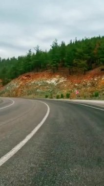 Dağ yolunda dar geçitten geçen birinci şahıs videosu. Görüntüler dağ yolu boyunca yolculuğu gösteriyor. Kamera dağ yolunda manzaralı bir yolculuk yakalar. Yüksek kalite 4k görüntü