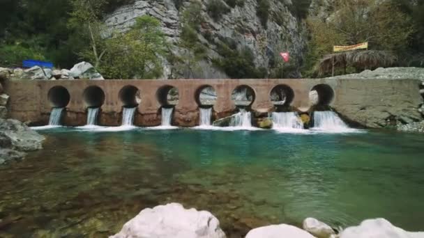 Drohne Erfasst Brücke Über Felsigen Gebirgsbach Klares Wasser Fließt Unter — Stockvideo