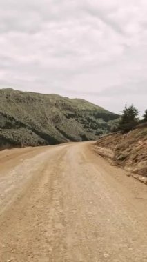 Dağlık yol boyunca dağ geçidinden birinci şahıs manzarası. Manzaralı yolculuk, dağ yolunu doğal ortamda yakalar. Video dağ yolunda yolculuğu gösteriyor, manzaraları gösteriyor.. 