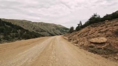 Dağlık yol boyunca dağ geçidinden birinci şahıs manzarası. Manzaralı yolculuk, dağ yolunu doğal ortamda yakalar. Video dağ yolunda yolculuğu gösteriyor, manzaraları gösteriyor.. 