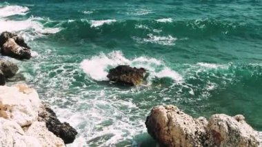 Serene Waters Dance: Turkuaz Dalgalar Doğa Taşı ile Tanışıyor Turkuaz deniz dalgalarının güzelliğini deneyimleyerek doğanın sakinleştirici sesleriyle çevrelenmiş görkemli kayalara çarpıyor. 