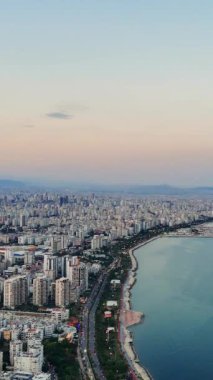 Akdeniz 'de güneş batarken Mersin, Türkiye' nin güzelliğini gösteren büyüleyici bir insansız hava aracı videosu.