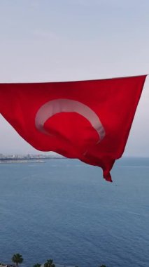 Türk bayrağının yakın çekim görüntüsü, canlı kırmızı rengini ve rüzgarda zarif bir şekilde dalgalanan yıldız ve hilal sembolünü gösteriyor..