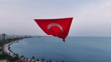 Türk bayrağının yakın çekim görüntüsü, canlı kırmızı rengini ve rüzgarda zarif bir şekilde dalgalanan yıldız ve hilal sembolünü gösteriyor..