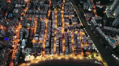 Türkiye 'nin Mersin kentinin günbatımından sonra çekilmiş büyüleyici hava görüntüsü. İnsansız hava aracının şehrin üzerinde yükselişini, aydınlık sokaklarının ve binalarının güzelliğini gösterişini izleyin..