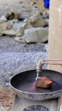 Yetenekli bir işçi bir parça bakır kesmek için oksijen meşalesi kullanır ve bu görev için gerekli olan kesin kontrolü gösterir..