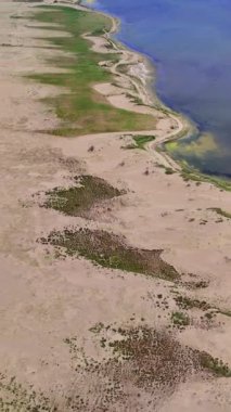 Tuz gölü ile deniz arasındaki hava görüntülerinde eşsiz bir kıyı manzarası görülüyor. Tükürük, tuzlu gölü denizden ayırır ve farklı ortamlar yaratır. Manzaralı tükürük çeşitli vahşi yaşam için yaşam alanı sağlar.