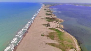 Tükürük üzerinde uçan bir dron, tuzlu göl ile okyanus arasındaki çarpıcı kontrastı yakalıyor..