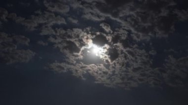 Gece gökyüzünde hareket eden bulutlarda parlayan ayı yakala. Doğa temalı projeler veya büyüleyici bir arkaplan ögesi olarak ideal