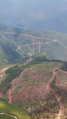 Şok edici bir hava keşfi yaşayın. Sabahın sakin saatleri boyunca gür ve canlı ormanlarla kaplı görkemli dağların üzerinde bir dron zarifçe süzülüyor..