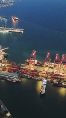 İnsansız hava aracı gece limanında aydınlık liman tesislerini vurguluyor. Port vinçleri yükleme ve boşaltma sahneleri gece gökyüzü altında hareketli liman faaliyetlerini etkin çalışan vinçlerle yakalıyor..