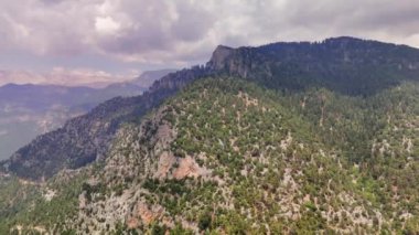 Orman dağlarının üzerinden uçan bir dronun panoramik görüntüsü çarpıcı zirveleri yakalar. Bu video doğal güzelliği ve görkemi gözler önüne serer. Geniş ve verimli orman dağları.