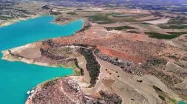 Turkuaz sular, tarım alanlarının yanında manzarayı kucaklayarak çarpıcı bir yarımada oluşturuyor. Huzurlu ortam, doğa ve kırsal yaşam arasındaki dengeyi vurguluyor.