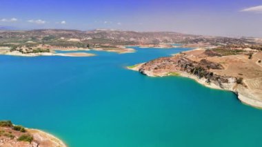 Hava manzaraları, engebeli uçurumlar ve geniş açık gökyüzünün yer aldığı sakin mavi bir kıyı şeridini yakalıyor, çarpıcı doğal güzellik ve barışçıl bir manzara sunuyor.