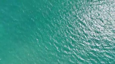 Turkuaz su güneş ışığı altında parıldıyor, sakin ve sakin bir atmosfer yaratıyor. Sakinleştirici görselleri ile turizm, rahatlama ve meditasyon projelerini geliştirmek için mükemmel.
