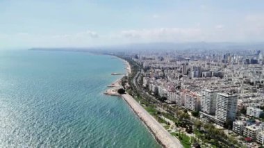 Kıyı şehirlerinde beyaz binalar, sakin bir plaj ve uzaktaki görkemli dağlar sergilenir. Sakin mavi sular sakin bir atmosfer yaratarak manzarayı güzelleştirir.