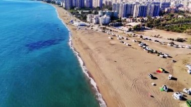 Arabalar Mersin 'in yanındaki sahilde, hindi, Akdeniz parlak mavi parıldarken, yumuşak dalgalar kumlu kıyı şeridine çarpıyor.