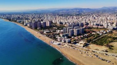 Mersin 'in büyüleyici manzaraları, hindi parlak mavi gökyüzünün altında çağdaş mimari, çarpıcı bir plaj ve ışıldayan Akdeniz ile canlı bir şehir manzarasını ön plana çıkarıyor.